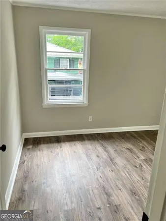 a view of a room with wooden floor and window