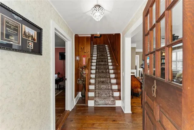 a kitchen with stainless steel appliances granite countertop a refrigerator a sink dishwasher a stove and white cabinets with wooden floor