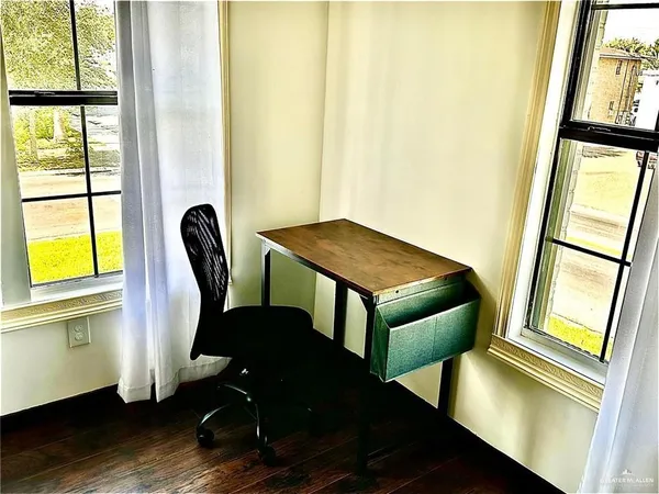 a view of a workspace with furniture and a window