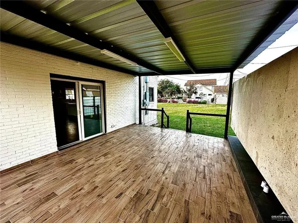 a big room with wooden floor and next to a window
