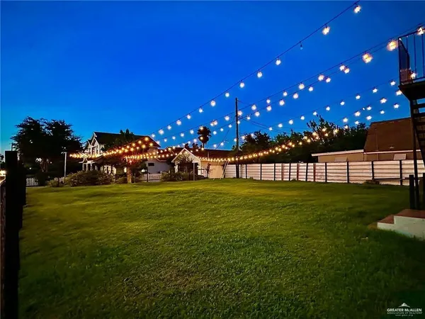 a view of a house with a big yard and a large trees