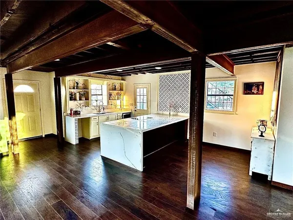 a living room with stainless steel appliances kitchen island granite countertop furniture and a large window