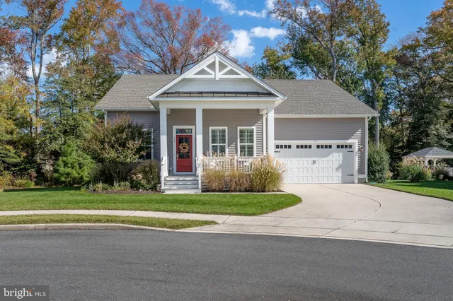 a front view of a house with a garden and trees