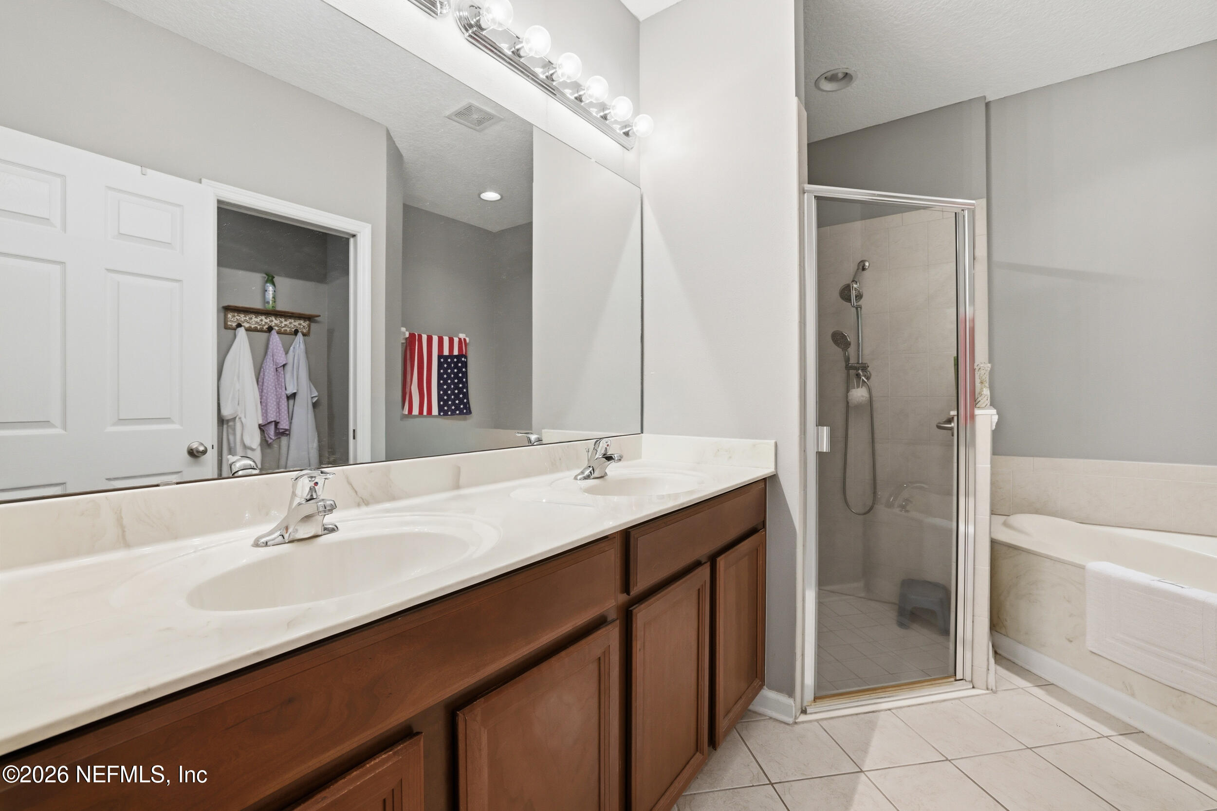 3260 Chestnut Ridge Way Orange Park, FL 32065 - Photo 20 of 39 a bathroom with a double vanity sink mirror and a bathtub