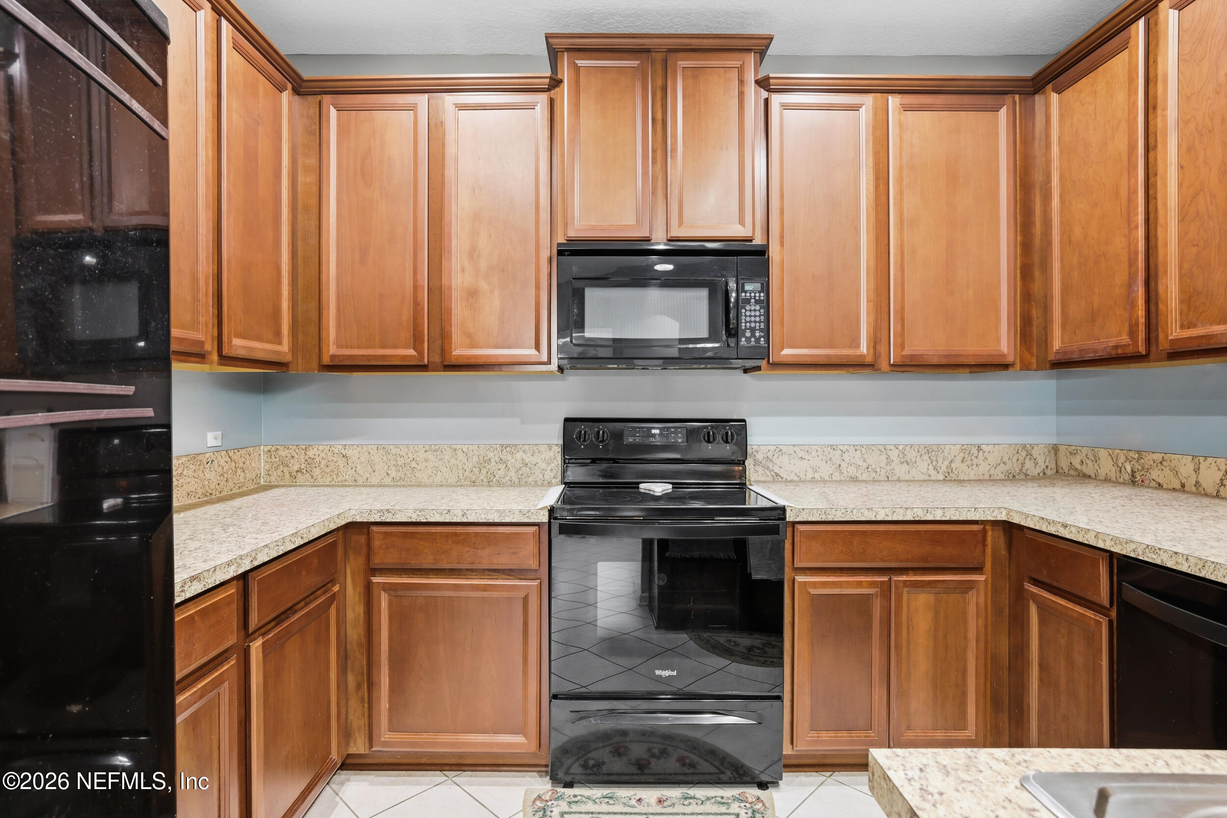 3260 Chestnut Ridge Way Orange Park, FL 32065 - Photo 10 of 39 a kitchen with granite countertop wooden cabinets and a stove top oven