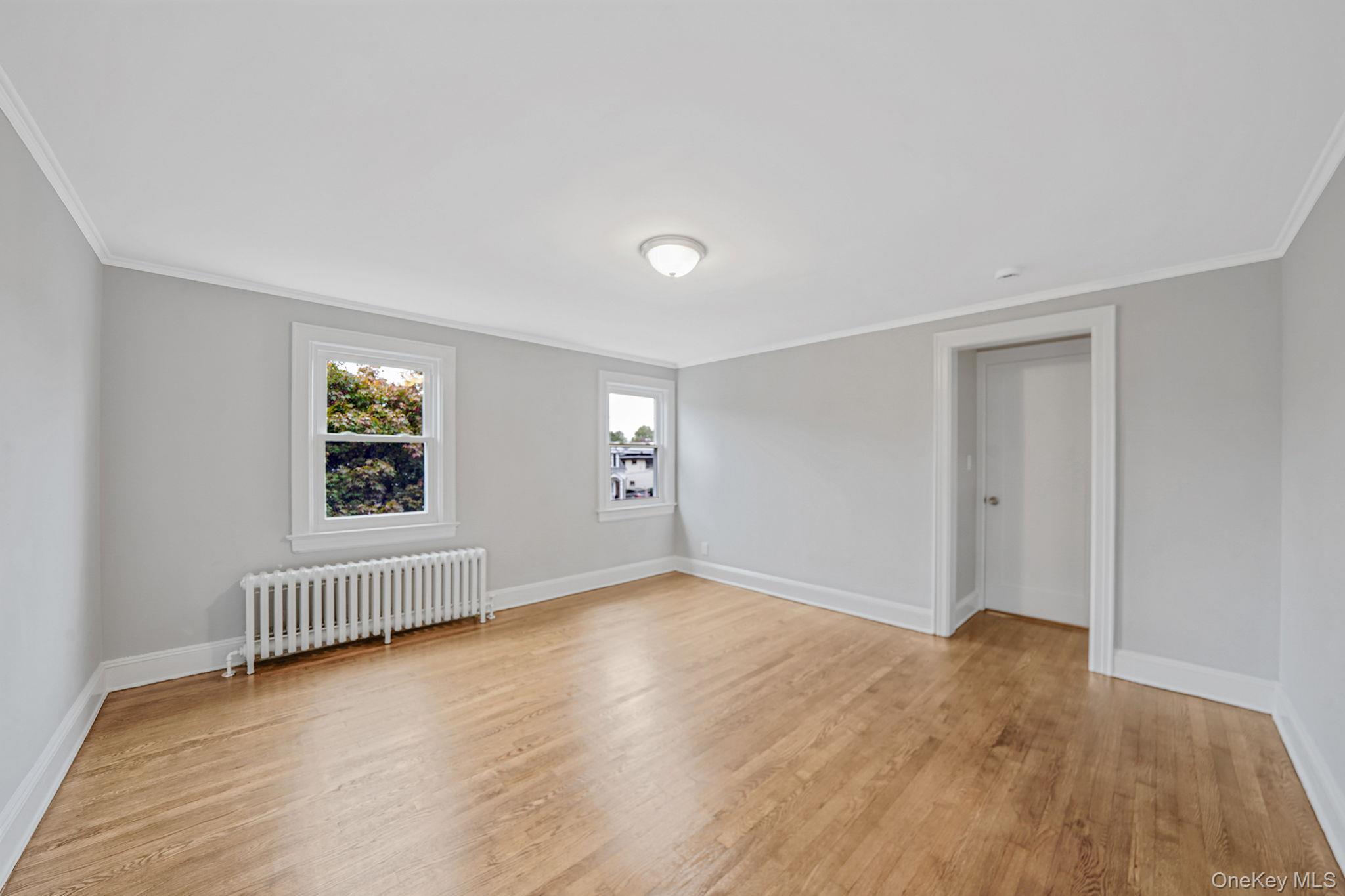 132 Duncan Road Hempstead, NY 11550 - Photo 15 of 21 an empty room with wooden floor and windows