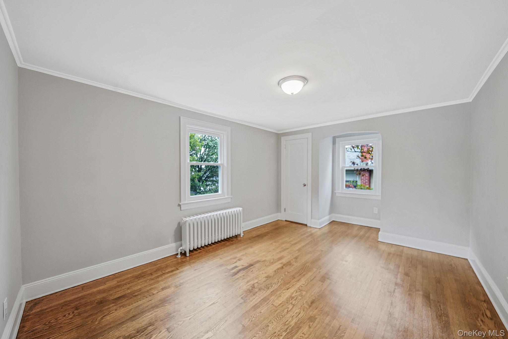 132 Duncan Road Hempstead, NY 11550 - Photo 16 of 21 an empty room with wooden floor and windows