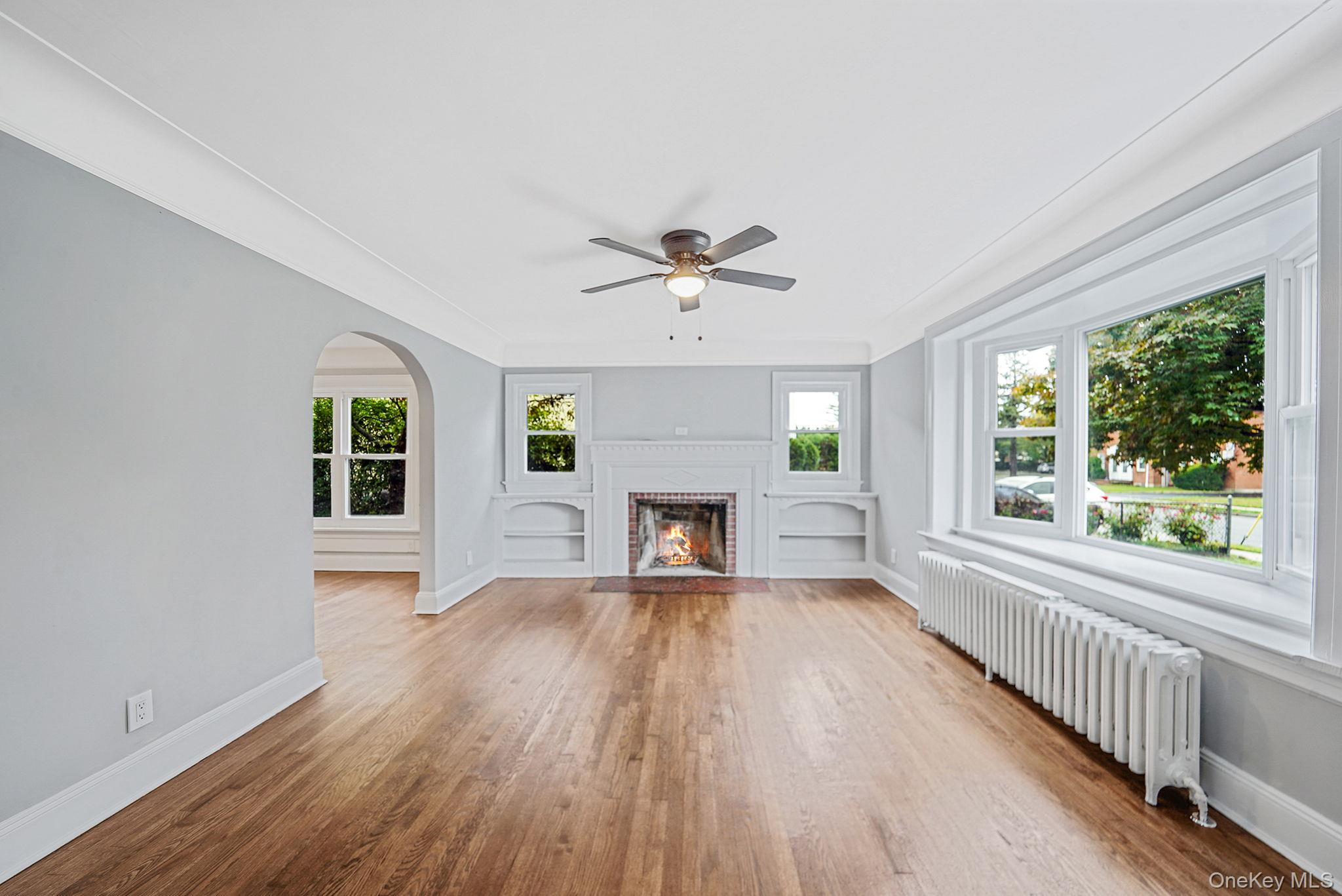 132 Duncan Road Hempstead, NY 11550 - Photo 7 of 21 wooden floor fireplace and windows in an empty room
