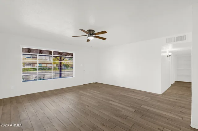 a view of empty room with wooden floor