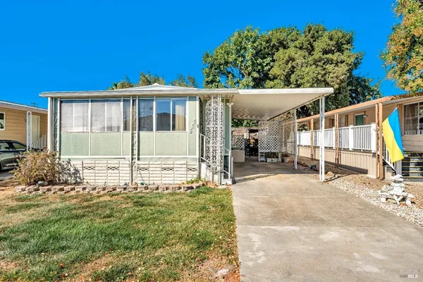 a view of a house with backyard and sitting area