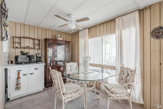 a kitchen with a table chairs refrigerator and cabinets