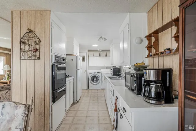 a view of a kitchen with furniture and refrigerator