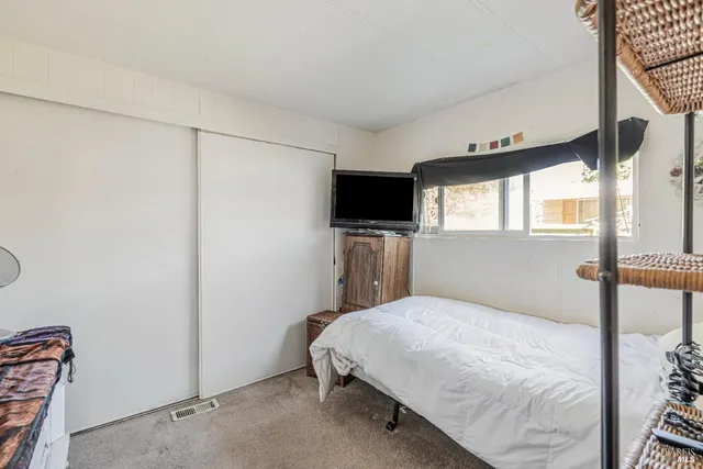 a bedroom with a bed and a flat screen tv