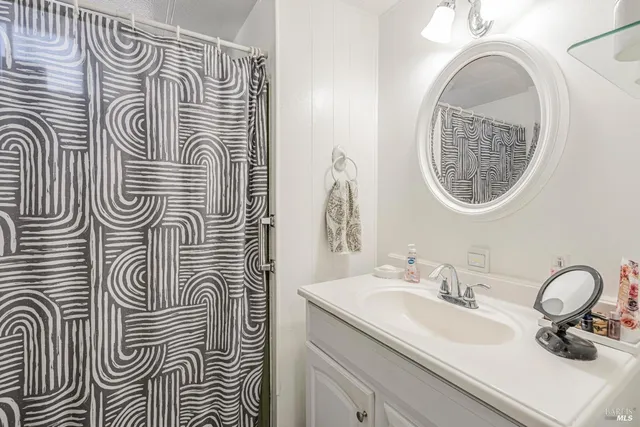 a bathroom with a sink a mirror and a shower curtain