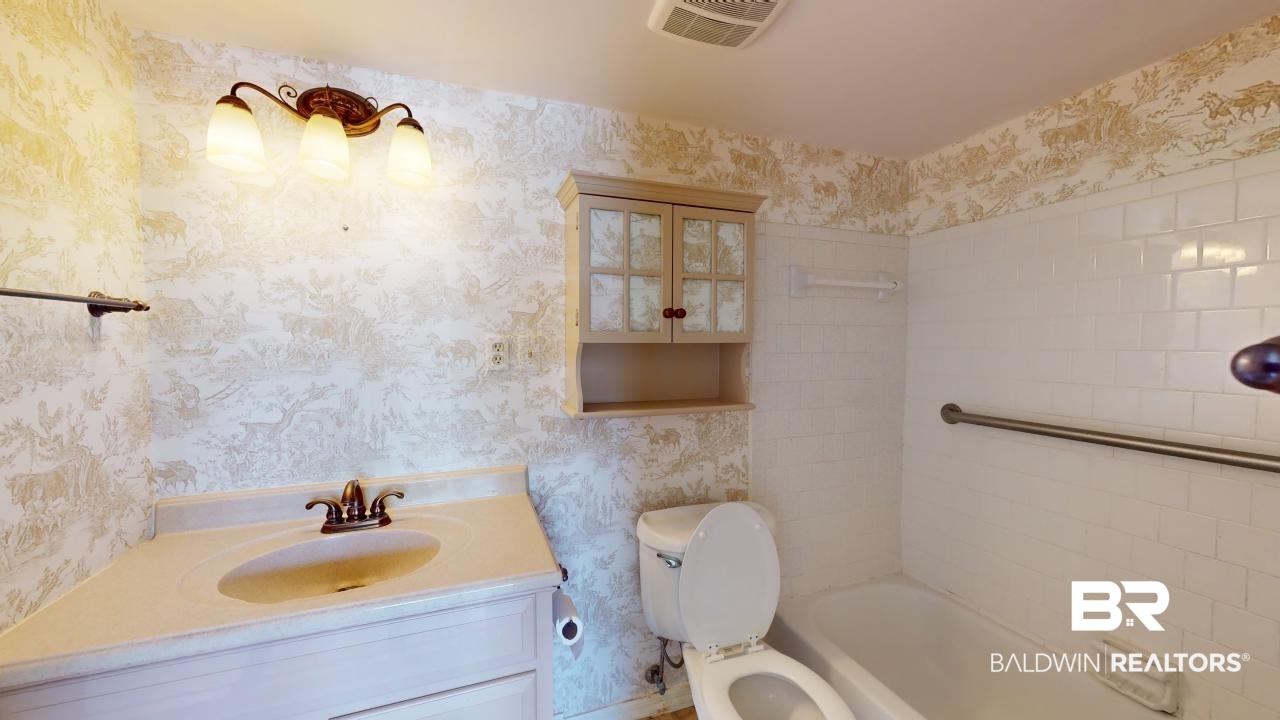 4009 Old Shell Road, Unit C13 Mobile, AL 36608 - Photo 16 of 32 Bathroom with wallpapered walls, toilet, vanity, and shower / washtub combination