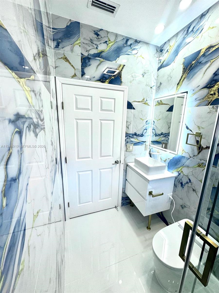 690 East 6th Place Hialeah, FL 33010 - Photo 7 of 18 a bathroom with a double vanity sink and mirror