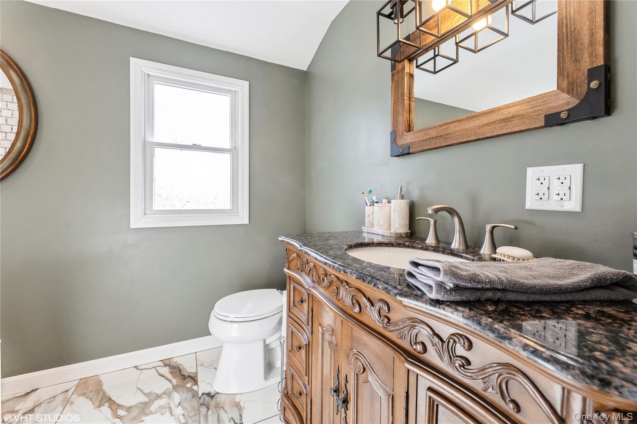 289 Quaker Road Pomona, NY 10970 - Photo 19 of 30 a bathroom with a granite countertop sink a toilet and a mirror