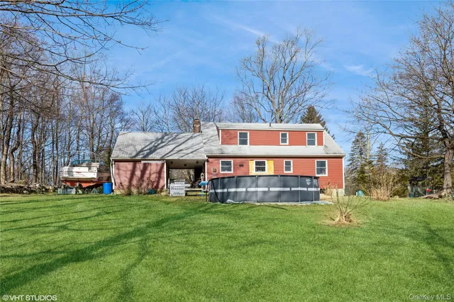 a view of a house with a big yard and large trees