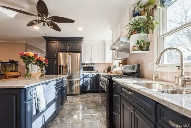 a kitchen with stainless steel appliances granite countertop a sink a stove and a refrigerator