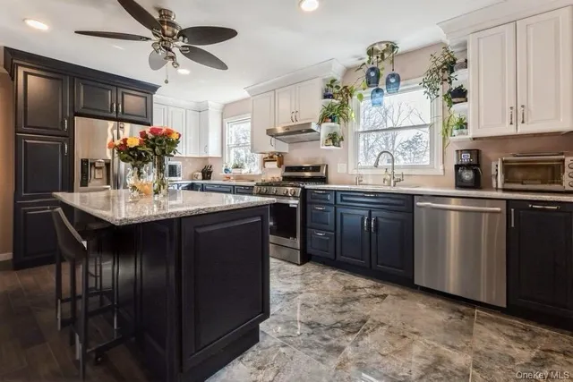 a kitchen with cabinets a sink stainless steel appliances and window
