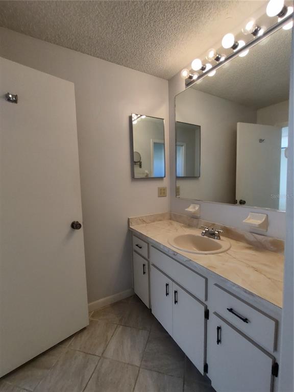 8491 Southwest 109th Street Ocala, FL 34481 - Photo 27 of 39 a bathroom with a granite countertop sink a light fixture and a mirror