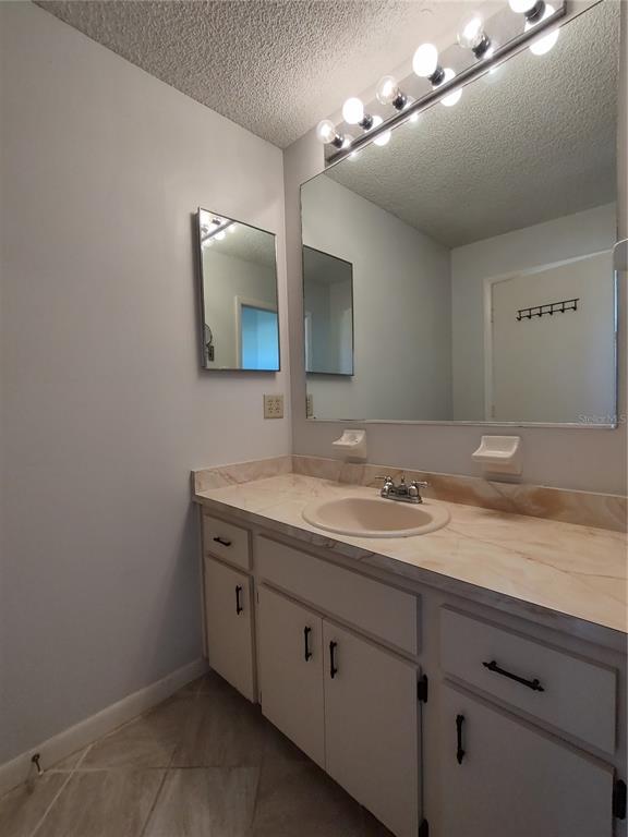 8491 Southwest 109th Street Ocala, FL 34481 - Photo 28 of 39 a bathroom with a granite countertop sink a large mirror and vanity