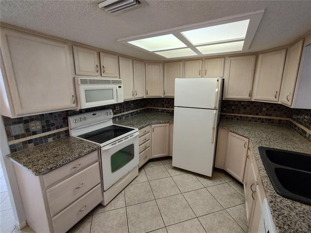 8491 Southwest 109th Street Ocala, FL 34481 - Photo 7 of 39 a kitchen with a stove a refrigerator and a sink