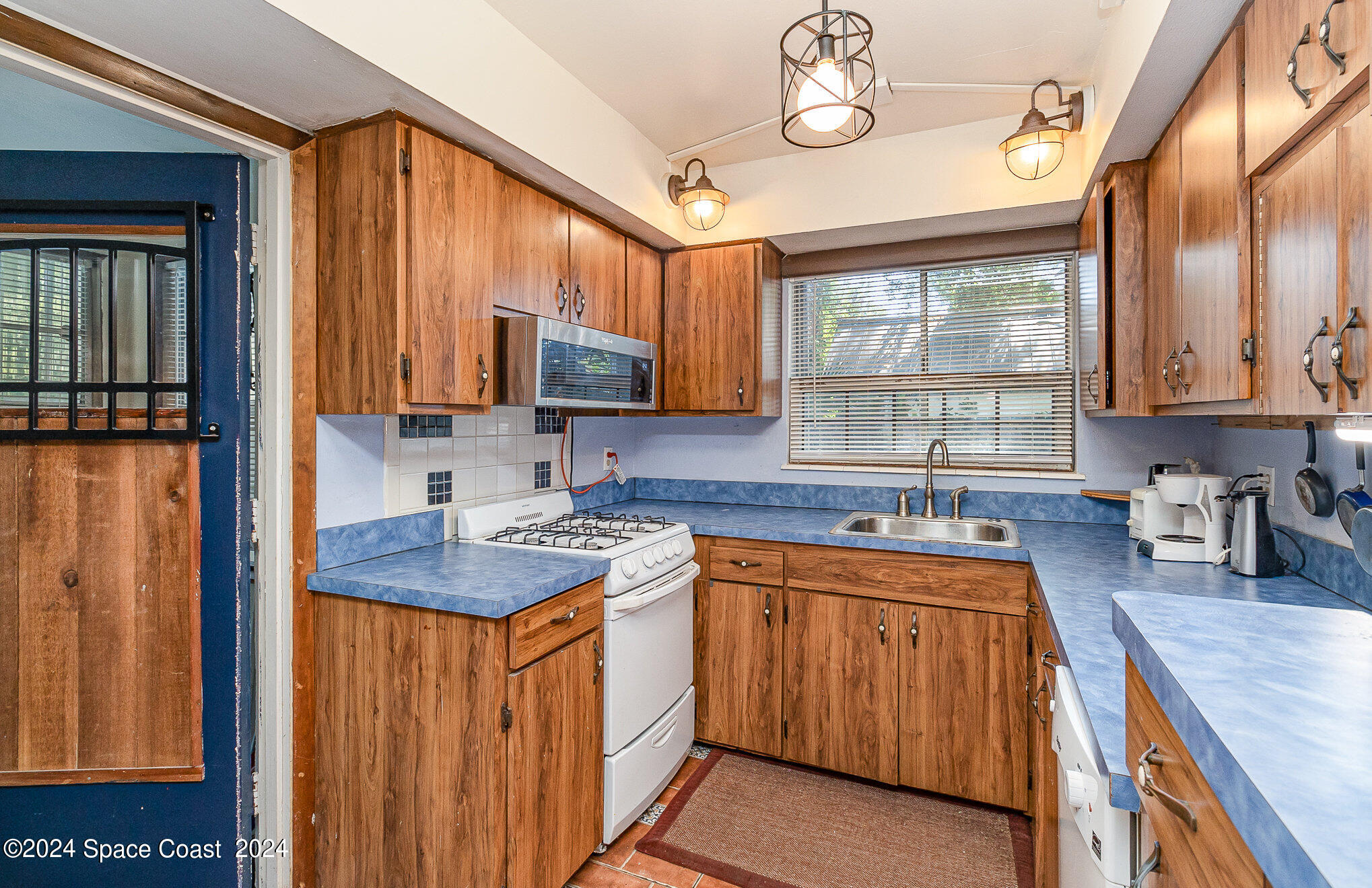 1707 Platt Street Melbourne, FL 32901 - Photo 10 of 32 a kitchen with stainless steel appliances granite countertop a sink stove and cabinets