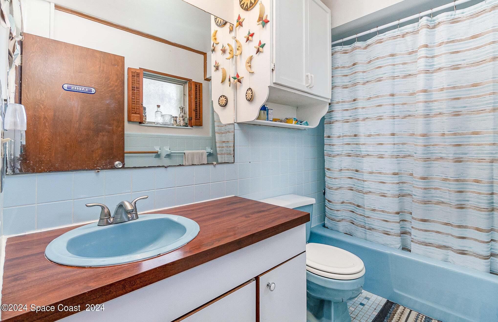 1707 Platt Street Melbourne, FL 32901 - Photo 14 of 32 a bathroom with a sink a toilet and a mirror