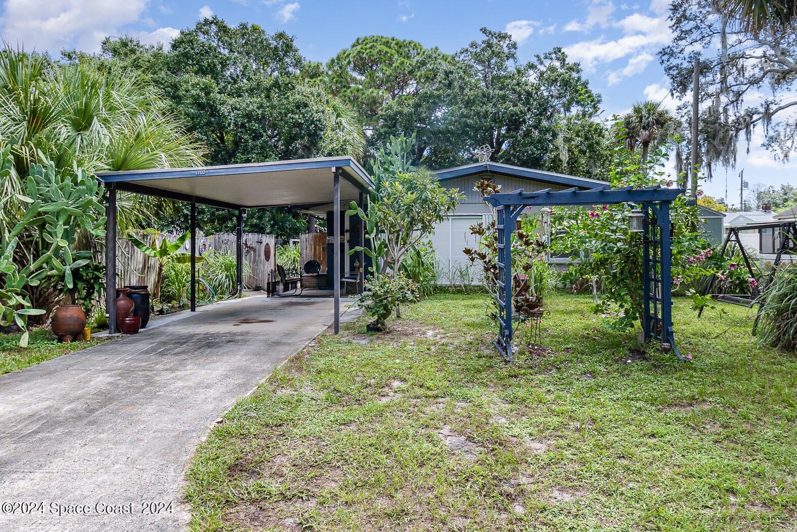 1707 Platt Street Melbourne, FL 32901 - Photo 2 of 32 a view of a backyard with a small cabin and a chair