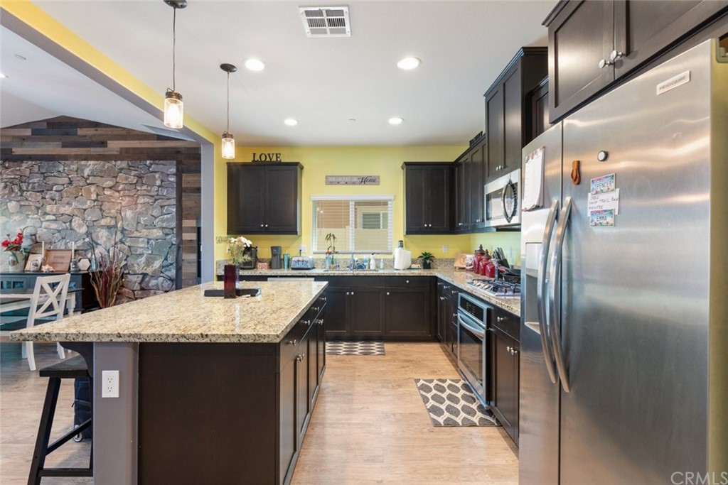 24802 Sandy Trail Place Menifee, CA 92584 - Photo 14 of 42 a kitchen with stainless steel appliances granite countertop a sink refrigerator and cabinets