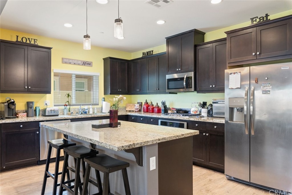 24802 Sandy Trail Place Menifee, CA 92584 - Photo 15 of 42 a kitchen with granite countertop a sink and steel appliances
