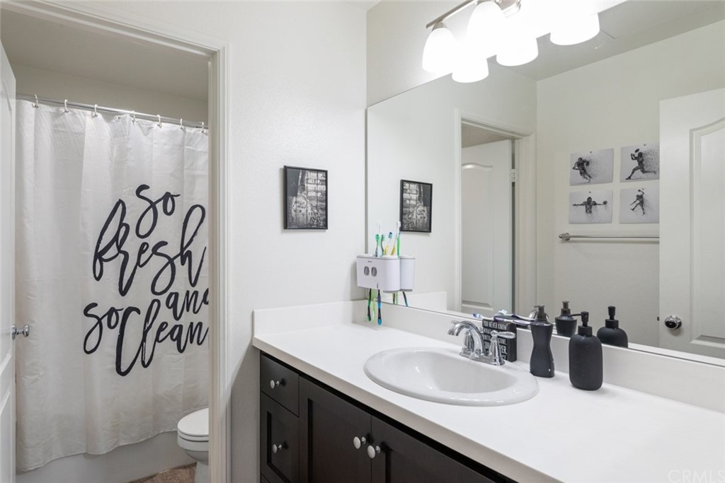 24802 Sandy Trail Place Menifee, CA 92584 - Photo 27 of 42 a bathroom with a sink a toilet and a mirror