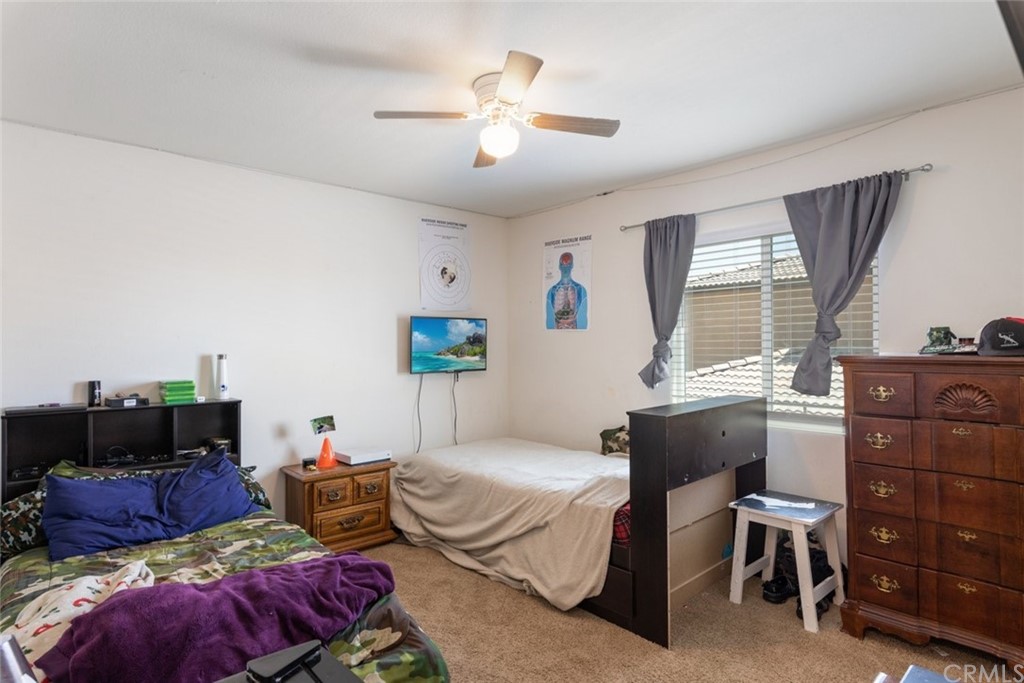 24802 Sandy Trail Place Menifee, CA 92584 - Photo 28 of 42 a bedroom with a bed and a chandelier