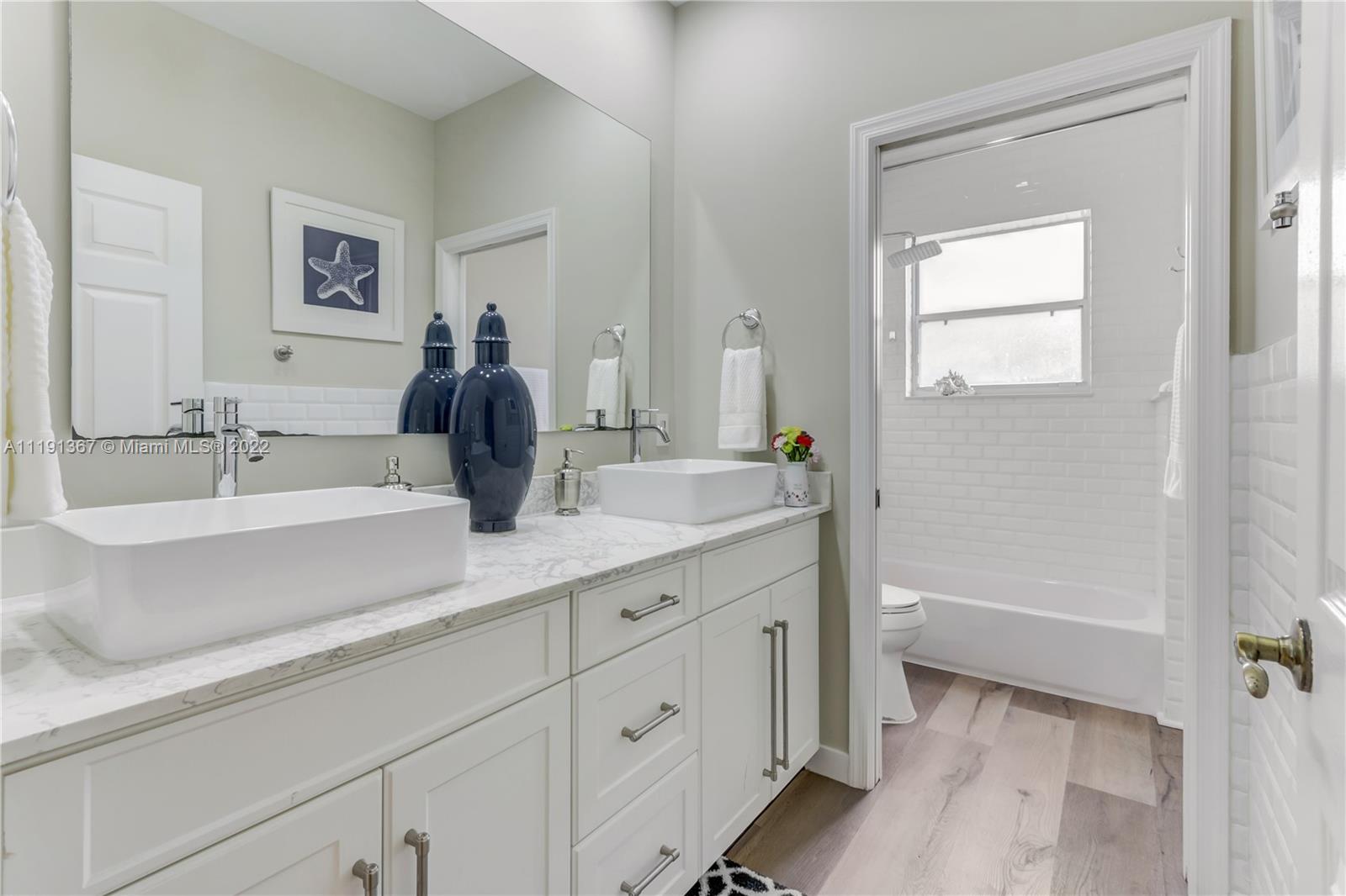 300 Mallard Road Weston, FL 33327 - Photo 31 of 46 a bathroom with a double vanity sink and mirror with bathtub