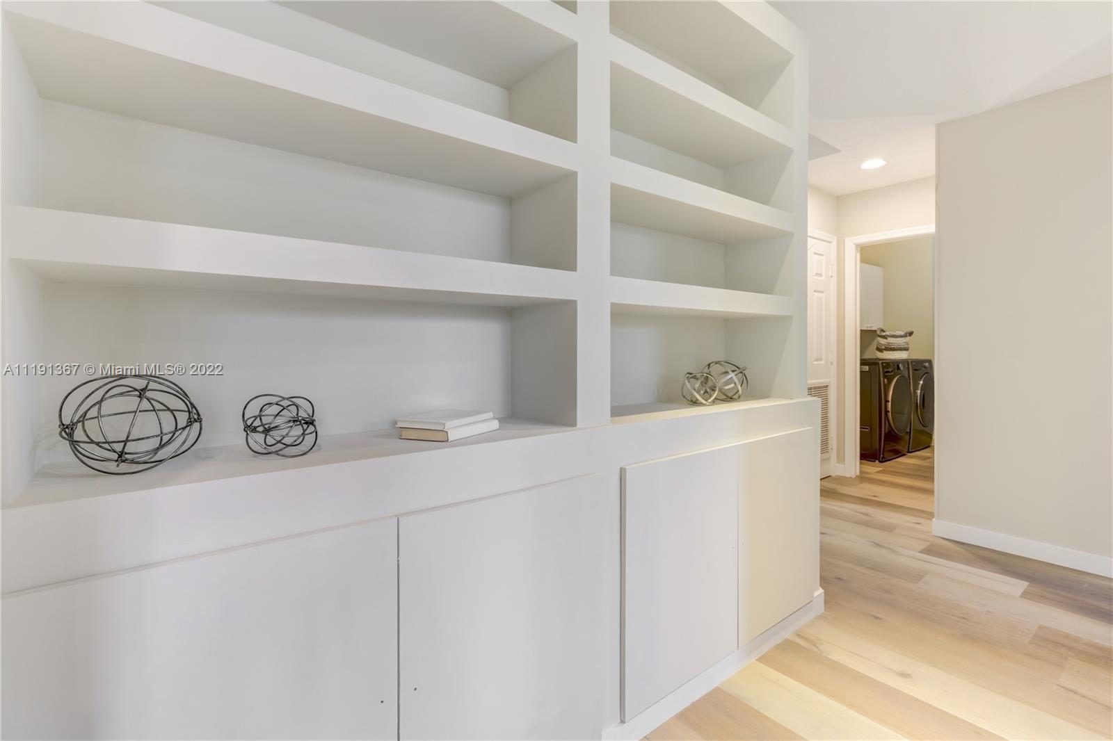 300 Mallard Road Weston, FL 33327 - Photo 32 of 46 a hallway with white cabinets and wooden floor