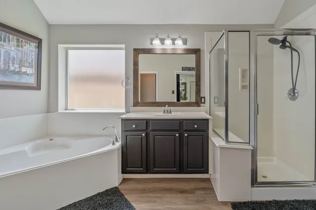 a bathroom with a tub sink and mirror