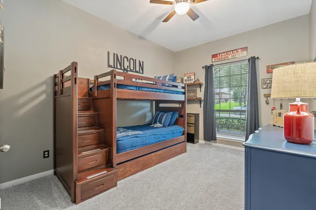 a bedroom with a bunk bed window and a dresser in it