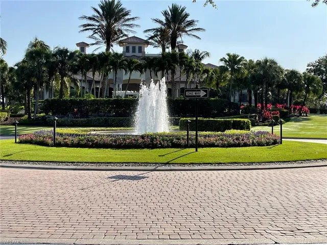 a front view of a house with a yard and palm trees