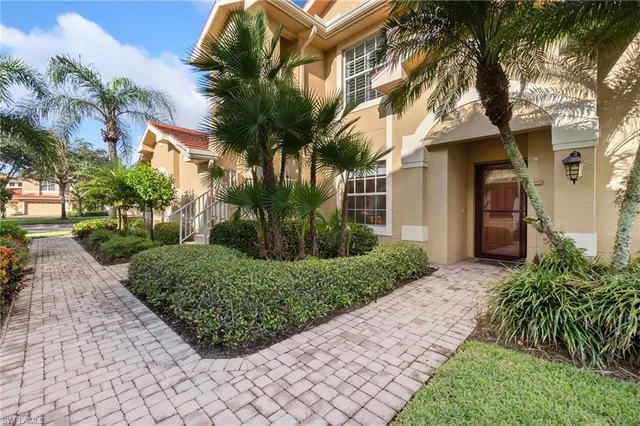 a front view of a house with a yard and potted plants