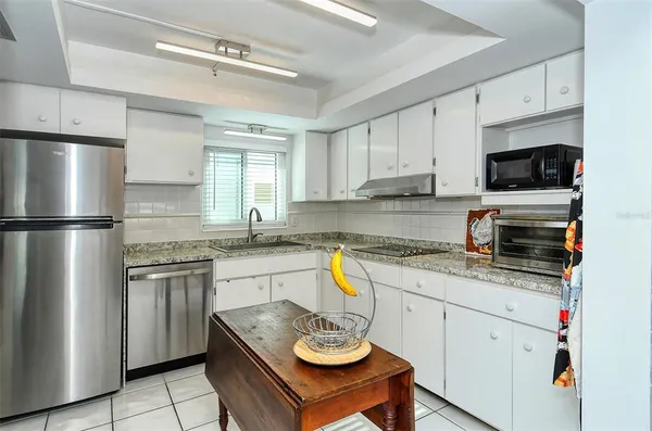 a kitchen with stainless steel appliances granite countertop a refrigerator and a stove top oven