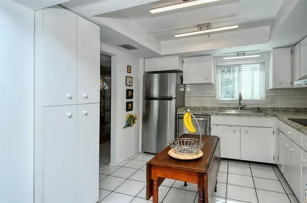 a kitchen with stainless steel appliances granite countertop a sink refrigerator and microwave