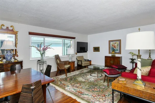a living room with furniture a window and a flat screen tv