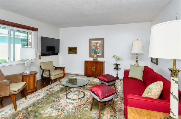 a living room with furniture a rug and a lamp