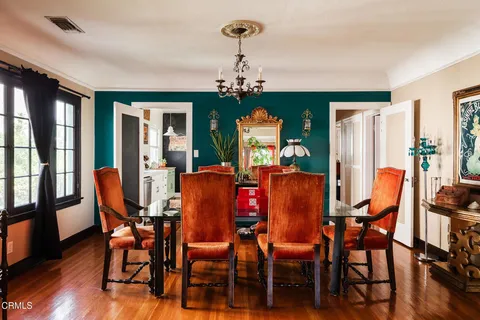 a dining room with furniture a chandelier and wooden floor