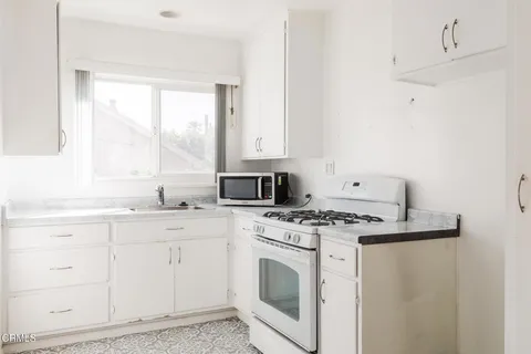 a kitchen with white cabinets and white appliances