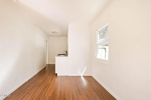 a view of a room with wooden floor and a window