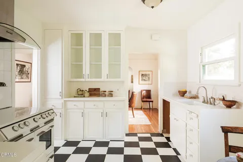 a kitchen with stainless steel appliances a stove a sink and a refrigerator a white cabinets