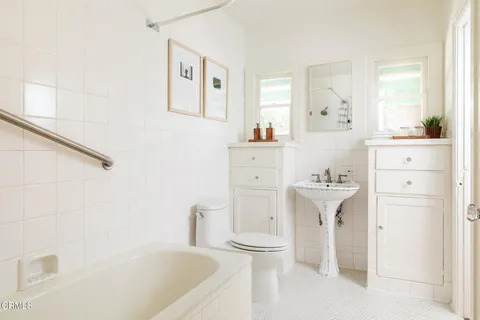 a bathroom with a sink a toilet and a mirror