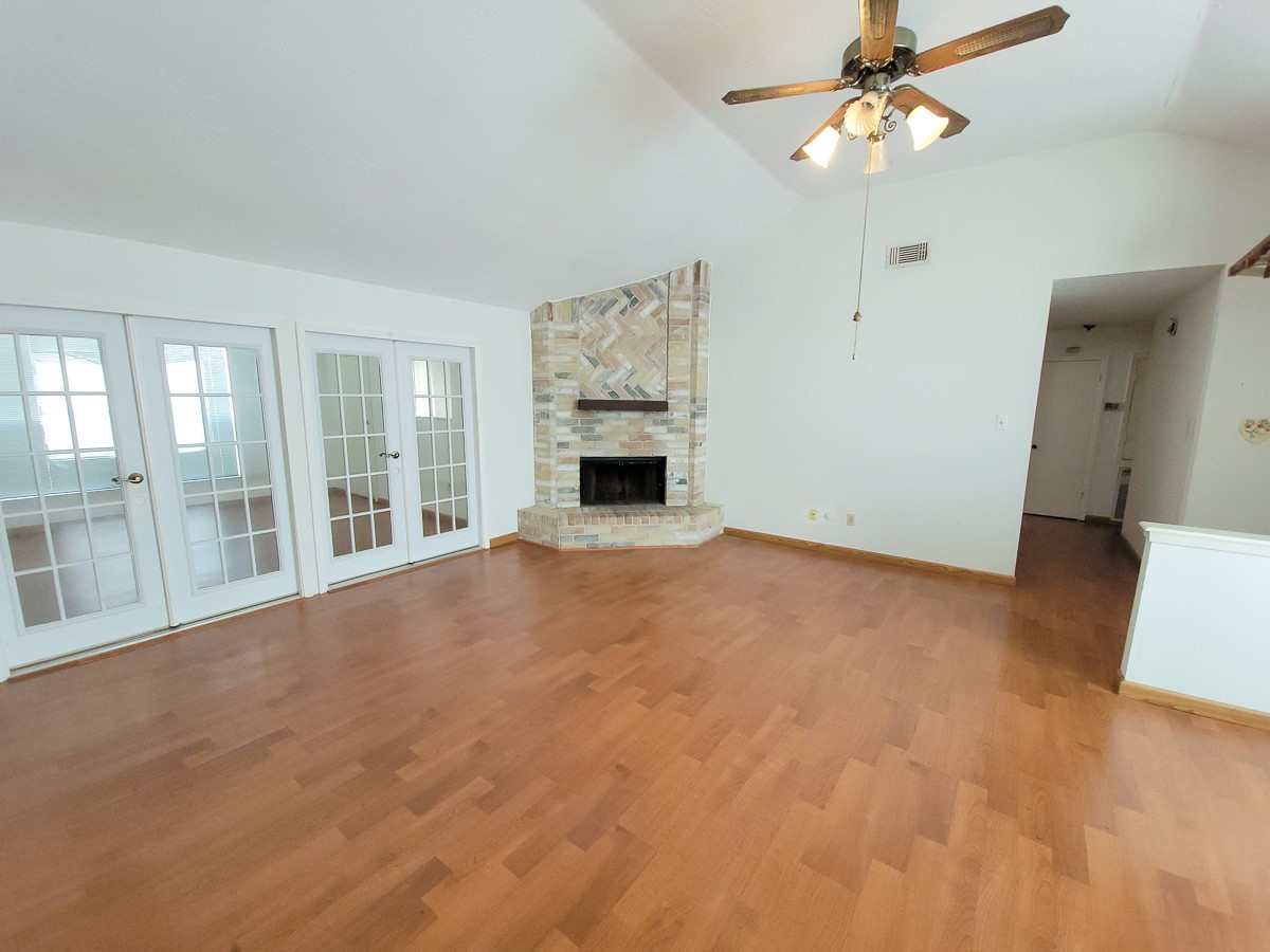 3430 Hombly Road Houston, TX 77066 - Photo 10 of 20 an empty room with windows fireplace and fan